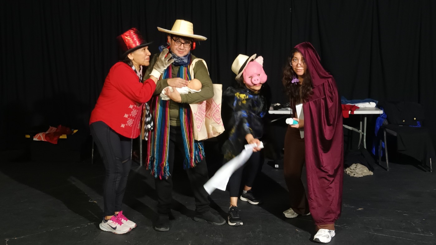Participantes del taller de actuación en personaje, con sombreros y rebozos, sobre el escenario.